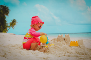 cute little girl play with sand on beach