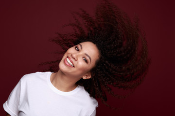 Studio photo of inspired african lady dancing with eyes closed. Indoor portrait of relaxed black girl isolated on purple background.