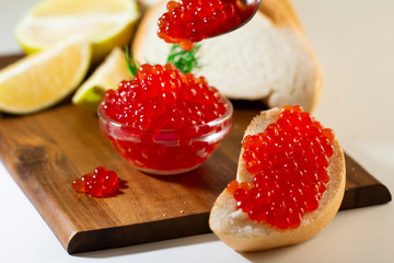 red caviar in glassware on wooden background with space for text