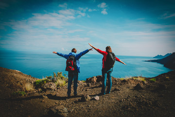 happy young couple hiking in mountains at sea