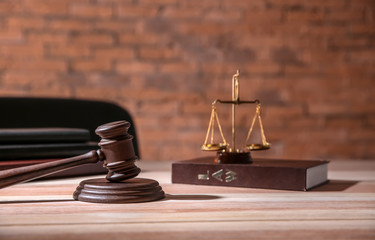 Judge gavel with law book and scales of justice on table