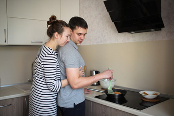 couple hugging together, baking pancakes