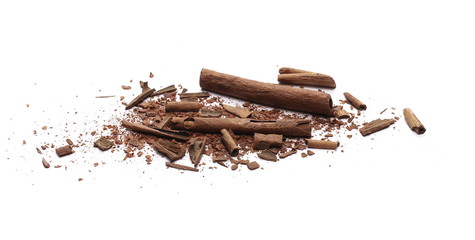 Cinnamon sticks with powder and shavings, macro isolated on white background
