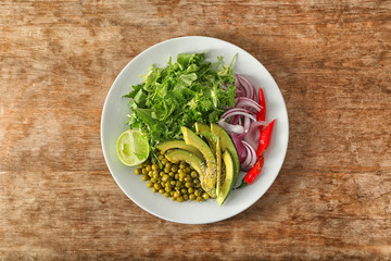 Plate with vegetables on wooden background
