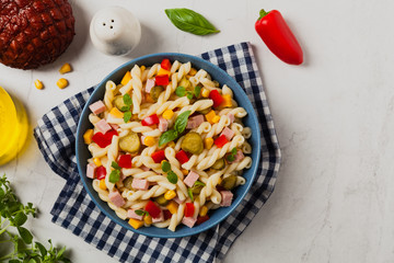 Italian fusilli pasta in a salad with ham and vegetables.