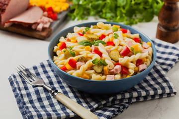 Italian fusilli pasta in a salad with ham and vegetables.