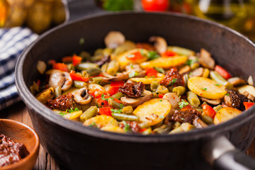 Fried pan vegetables, with mushrooms and dried tomatoes. Seasoned with a mix of herbs.