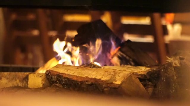 Burning in the fireplace in the comfort cozy cafe. Fireplace with just like fire. Tongues of flame in the fireplace.
