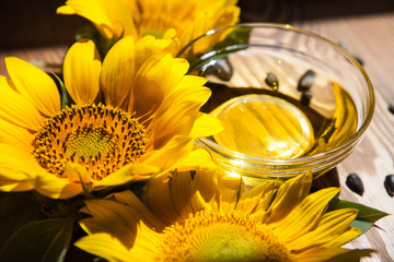 Sunflower oil and yellow flowers with sunshine on background, food ingredient