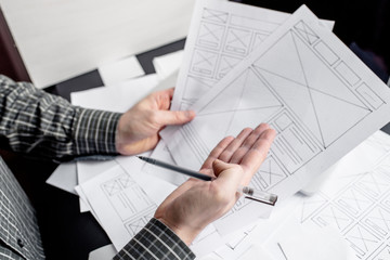UX website designer drawing wireframe sketch of prototype, framework, layout future project. Creative user experience concept website template. Designer workspace