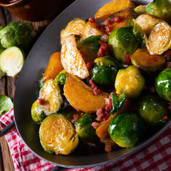 Brussels sprouts potato pan with bacon in rustic style