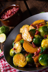 Brussels sprouts potato pan with bacon in rustic style