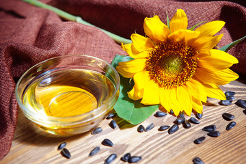 Sunflower oil in glass bowl and yellow flower