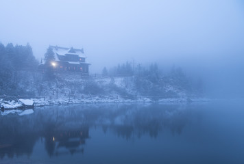 winter landscape with fog wooden shelter