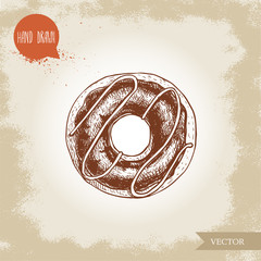 Hand drawn sketch style donut with chocolate cream and icing decoration.Vector illustration isolated on old background.
