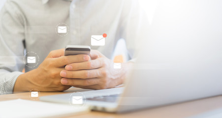 close up businessman holding smartphone and checking email online on web with virtual interface...