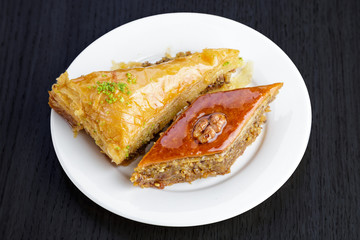 Traditional arabic dessert baklava with walnuts and cardamom, on a wooden table. Homemade baklava with nuts and honey.