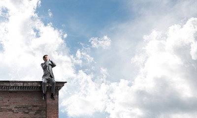 Young man on building edge do not want to see anything