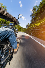 Motorcycle driver riding in Alpine highway, Nockalmstrasse, Austria, Europe.