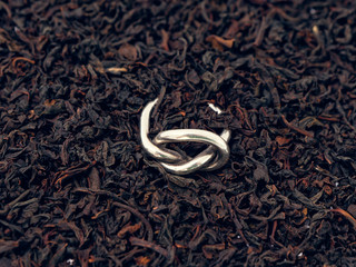 background of black tea leaves. precious ring. decorations.