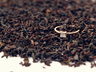 background of black tea leaves. precious ring. decorations.