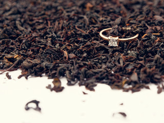 background of black tea leaves. precious ring. decorations.