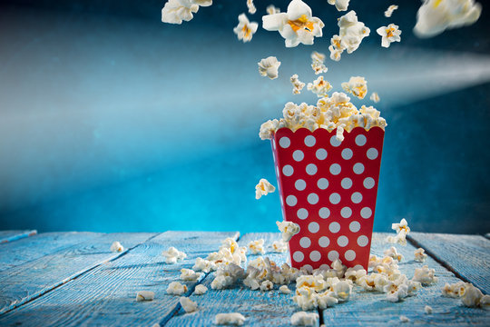 Box of popcorn on blue background.