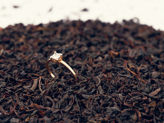 background of black tea leaves. precious ring. decorations.
