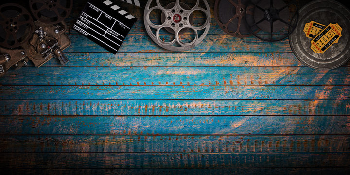Cinema concept of vintage film reels, clapperboard and projector.