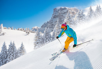 Skier skiing downhill in high mountains