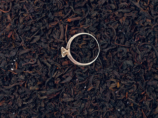 background of black tea leaves. precious ring. decorations.