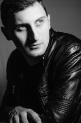A black&white portrait of a man in the leather jacket.