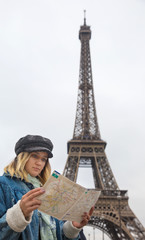 Young woman in Paris ,France looking at map or city guide. Travel and people concept.