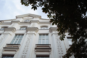 A white building with the clock photographed from below.