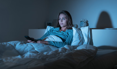 Woman watching tv in bed