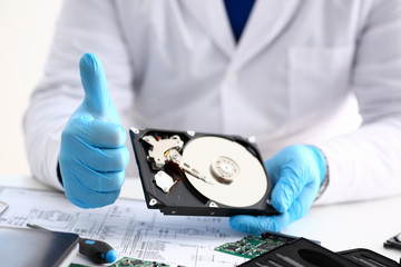 Male repairman wearing blue gloves is holding hard