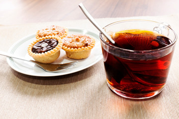 Tea time with hot tea and dessert tarts
