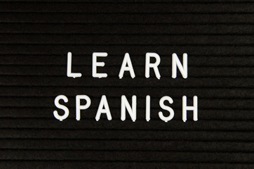 Learn Spanish language, modern looking sign on black background