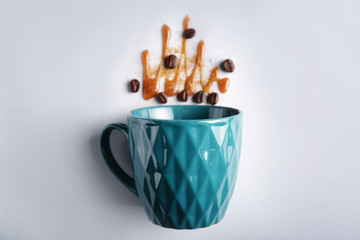 Composition with cup and coffee beans on light background