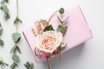Beautiful gift box and floral decor on white background