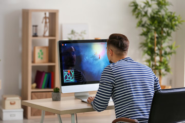 Young man playing computer game at home