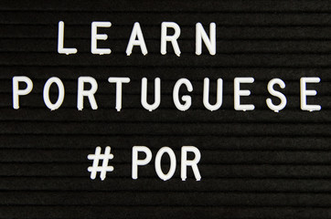 Fototapeta premium Learn Portuguese, POR abbreviation, simple sign on black background, great for teachers, schools, students