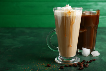 Glass cup of tasty coffee drink on color table