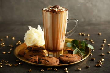 Tray with tasty cookies and coffee drink in glass cup on grey table