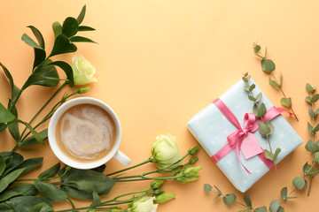 Fototapeta na wymiar Composition with gift box, flowers and cup of coffee on color background