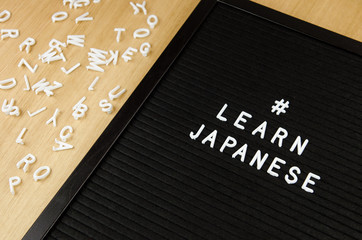 Learn Japanese JPN abbreviation, simple sign on black background, great for teachers, schools, students