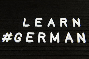 Learn German, GER abbreviation, simple sign on black background, great for teachers, schools, students