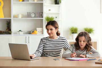 Busy mother with daughter working at home