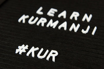 Fototapeta premium Learn Northern Kurdish Kurmanji language, KUR abbreviation, simple sign on black background, great for teachers, schools, students