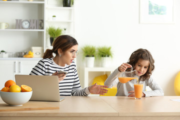 Stressed mother with naughty daughter working at home